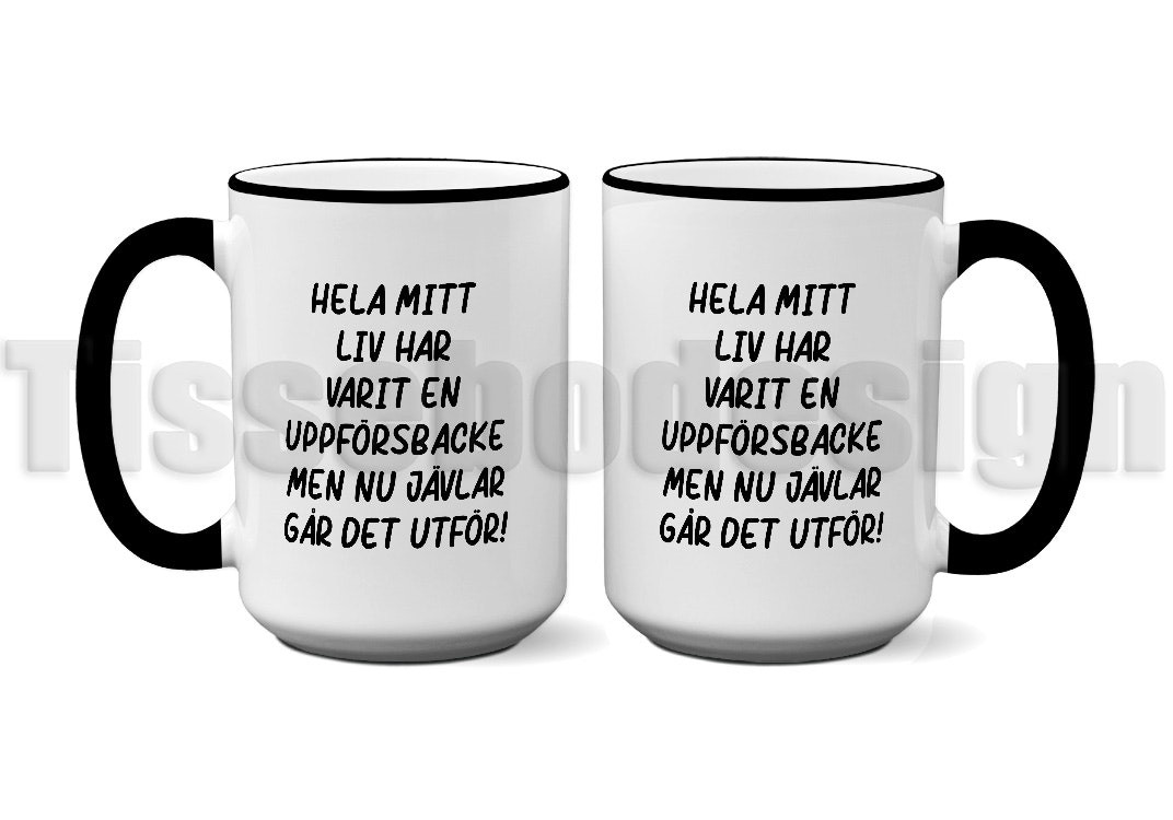 Vit keramikmugg med svart kant och handtag, med texten "Hela mitt liv har varit en uppförsbacke men nu jävlar går det utför!" tryckt på båda sidor. Rymmer 450 ml.