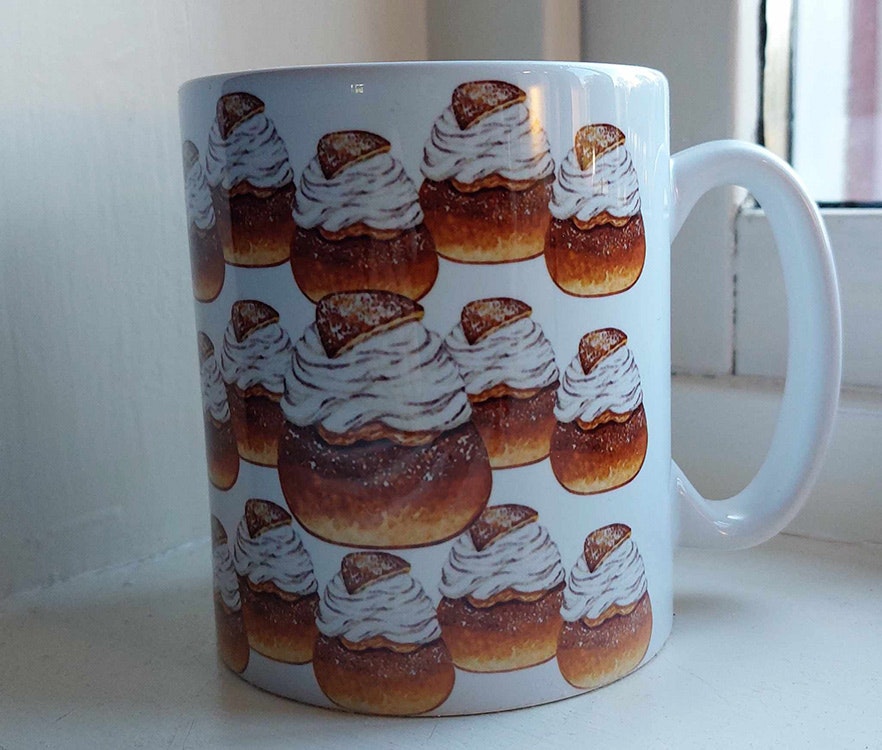 Vit keramikmugg med ett mönster av semlor runt hela muggen, 330 ml