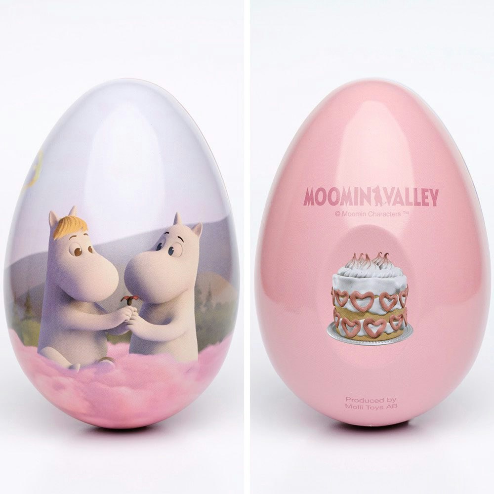 Muminpåskägg i rosa design med motiv av Mumin och Snorkfröken bland rosa moln på framsidan och en dekorerad tårta på baksidan.