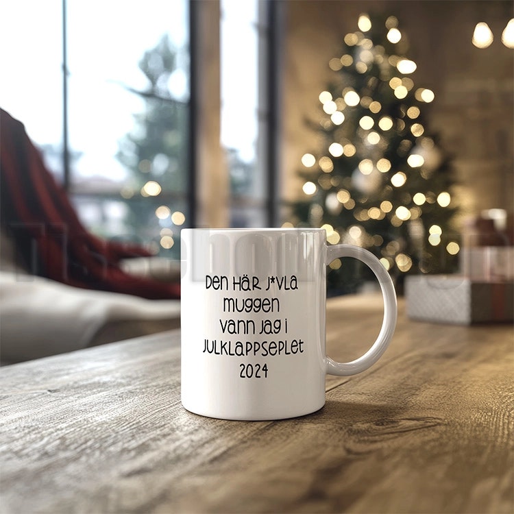 Vit keramisk mugg med texten "Den här j*vla muggen vann jag i julklappspelet 2024", 330 ml, med tryck på båda sidor.  Nr 2
