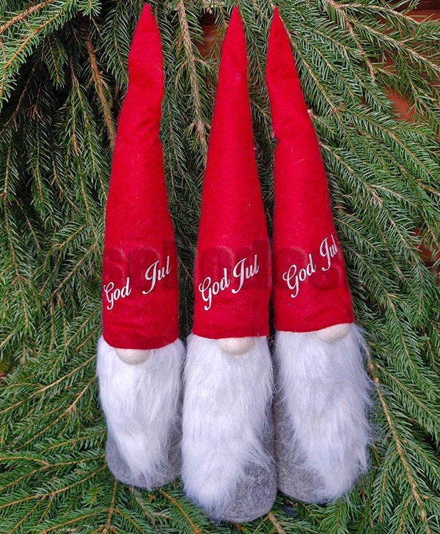Lång tomte med "God Jul"-tryck på röd luva, ca 48 cm hög, perfekt som juldekoration.