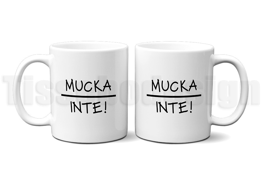Vit mugg med texten "Mucka Inte" i svart tryck, porslin 330 ml, tryck på båda sidor.