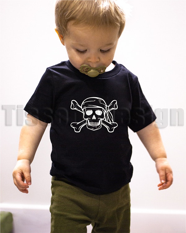 Barn T-shirt i 100% bomull med tryck av piratmotiv, rund halsringning, finns i vit och svart samt storlekar 90–160. Märke: Lager 157.