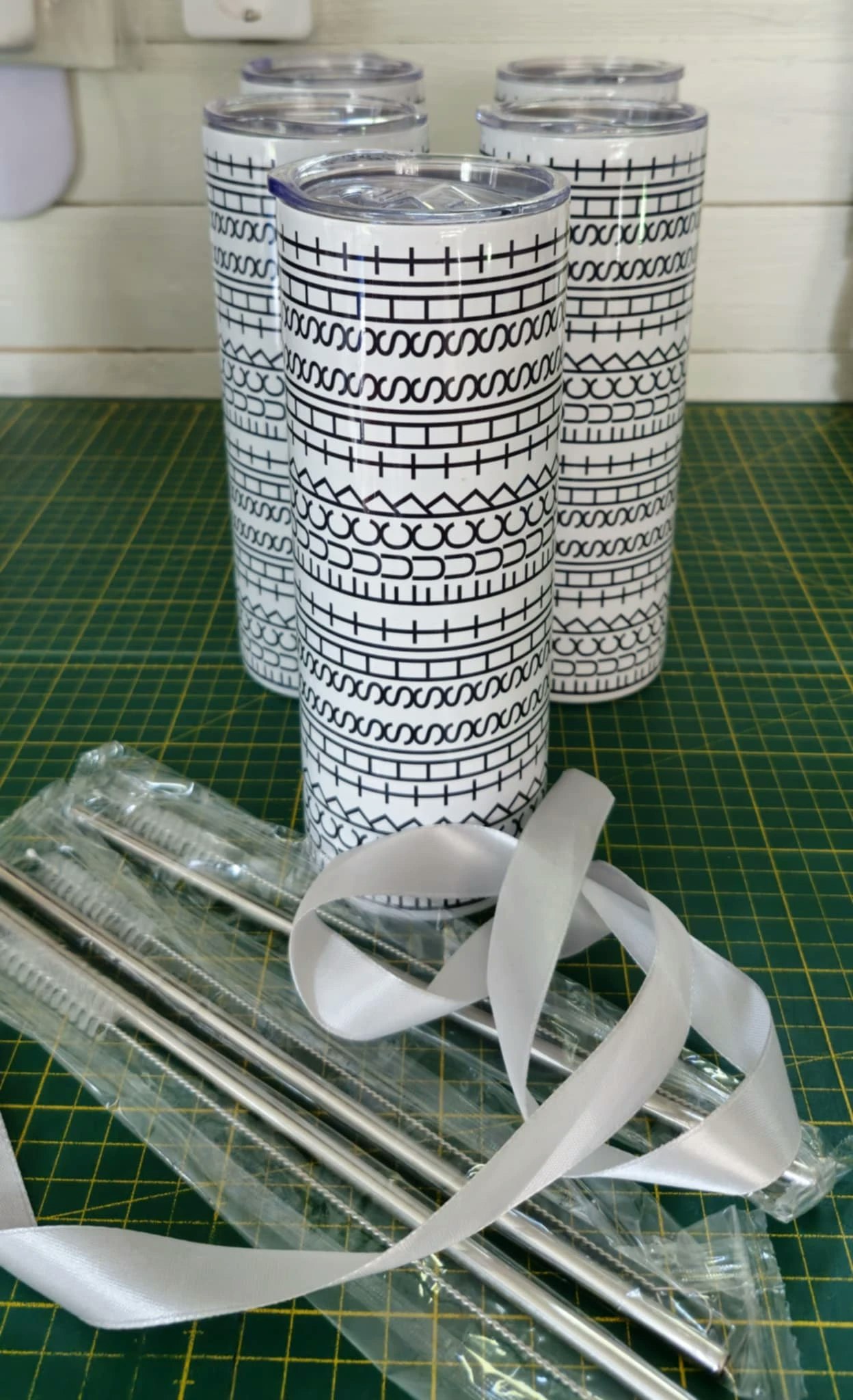 Tumbler med svartvit sömmönsterdesign – visas med exempel på mindre tryckfel