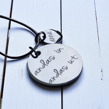 Graverat halsband "andas in andas ut"