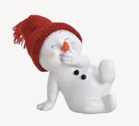 Snögubbe sittande med röd stickad mössa