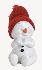 Snögubbe sittande med röd stickad mössa
