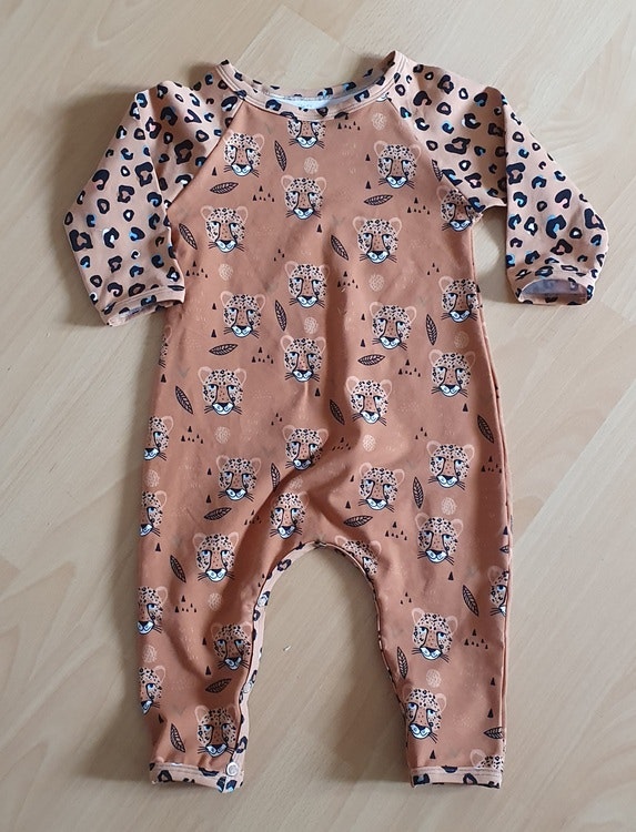 Bilden föreställer en jumpsuit för barn med leopard i ekologisk jersey/trikå.