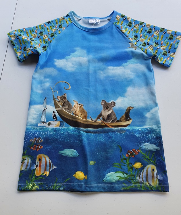Bilden föreställer en T-shirt med fiskande smådjur i ekologisk jersey/trikå.
