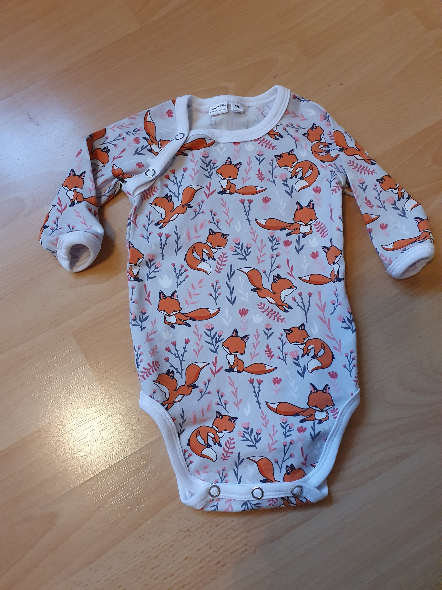 Bilden föreställer en babybody med rävar i ekologisk jersey/trikå.
