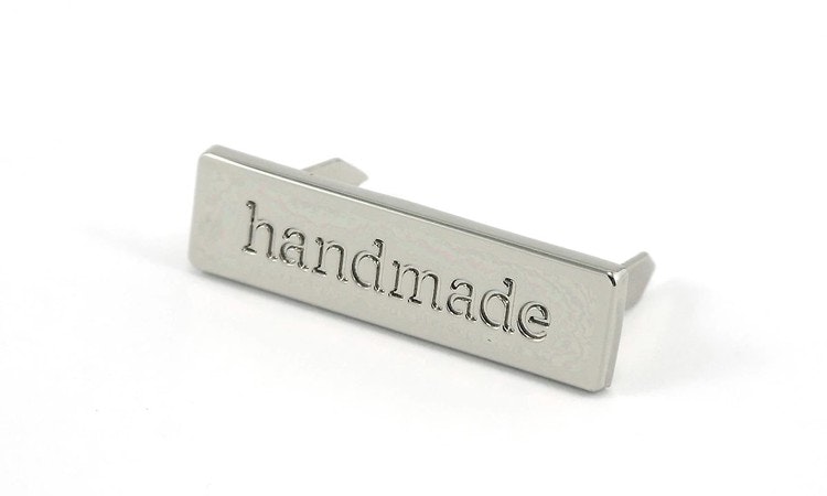 Metal bag label: "handmade", rectangle