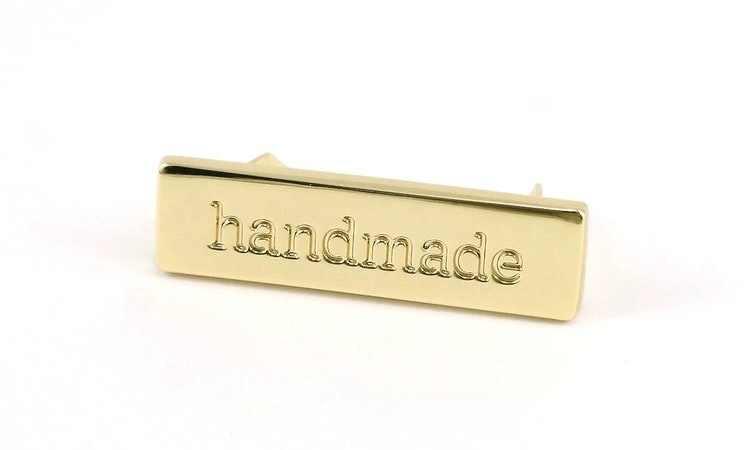 Metal bag label: "handmade", rectangle