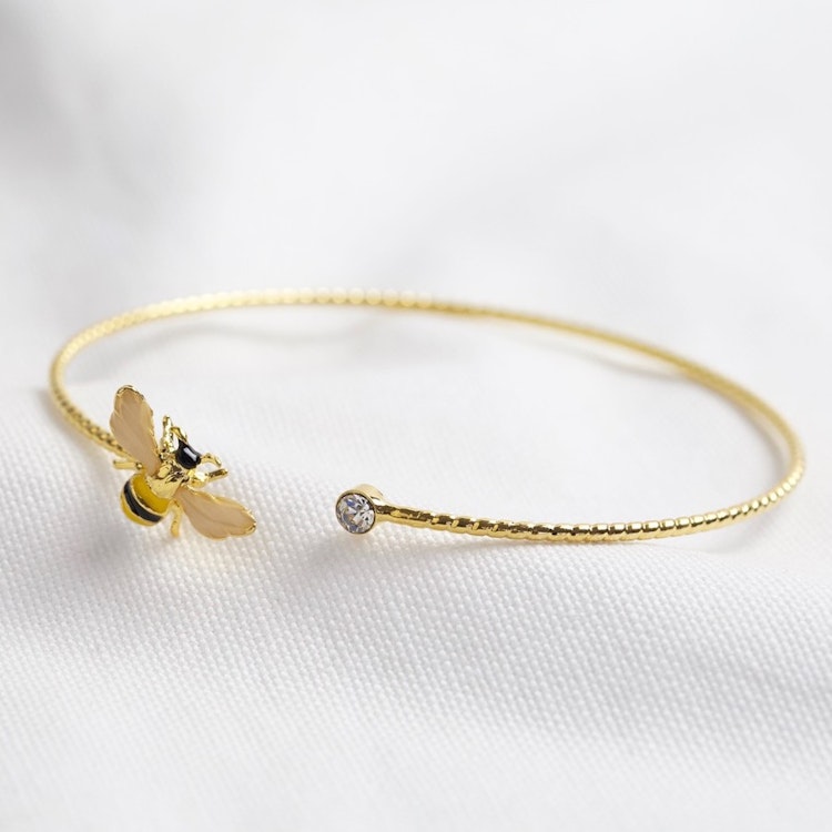 Bild på ett armband med ett emaljerat bi samt en glaskristall