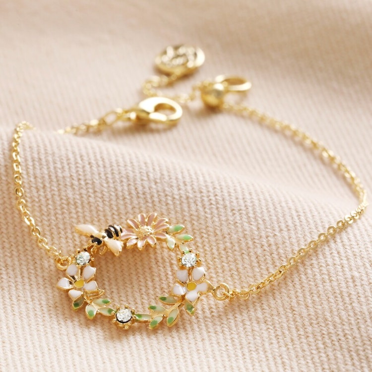 Bild på ett armband med en blomsterkrans med ett litet bi – guld
