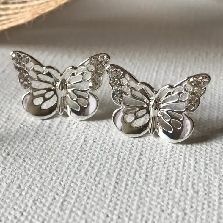 Bild på örhängen med silverfärgade fjärilar