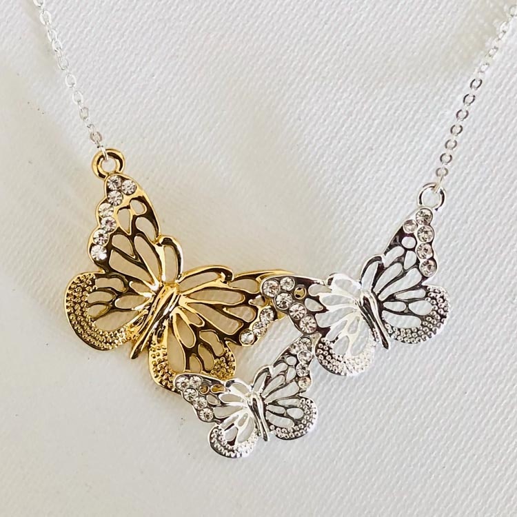 Bild med halsband med silver- och guldfärgade fjärilar