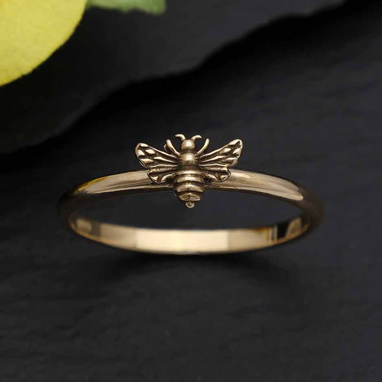Bild på en smal ring i brons med ett litet bi på
