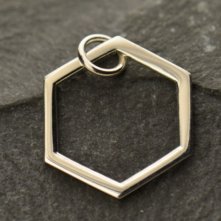 Bild på ett hänge i form av en hexagon i silver.
