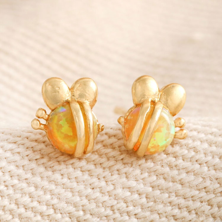 Bild på ett par örhängen som föreställer bin tillverkade av opalit