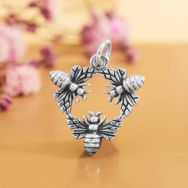 Bild på ett hänge i silver med tre bin som sammanlänkas till en triangel i silver.