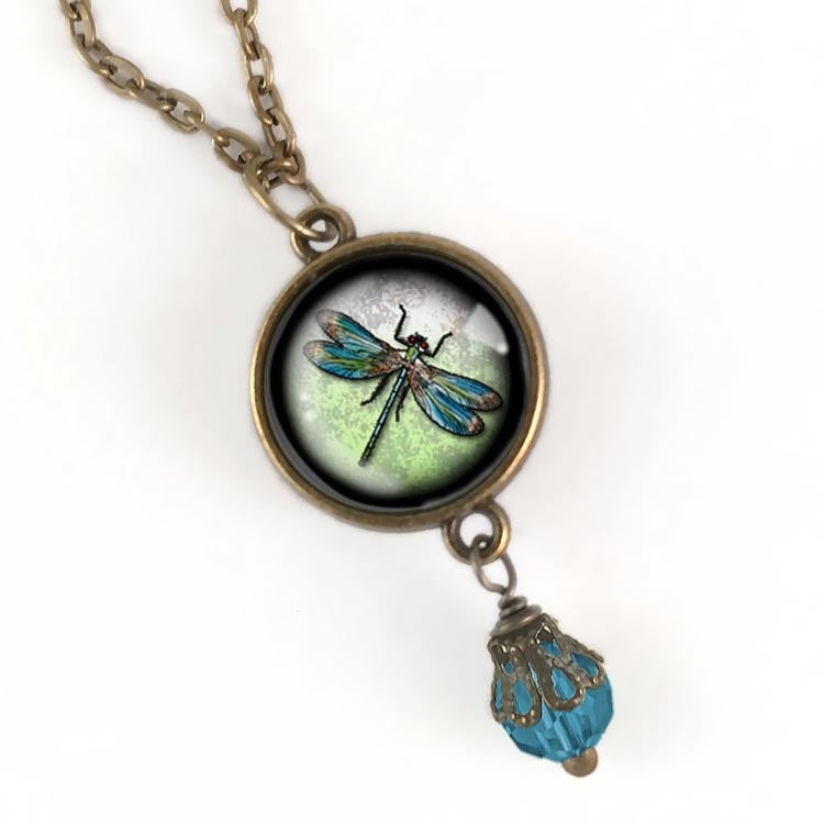 Bild på ett vintageinspirerat halsband med en berlock med en illustration av en trollslända