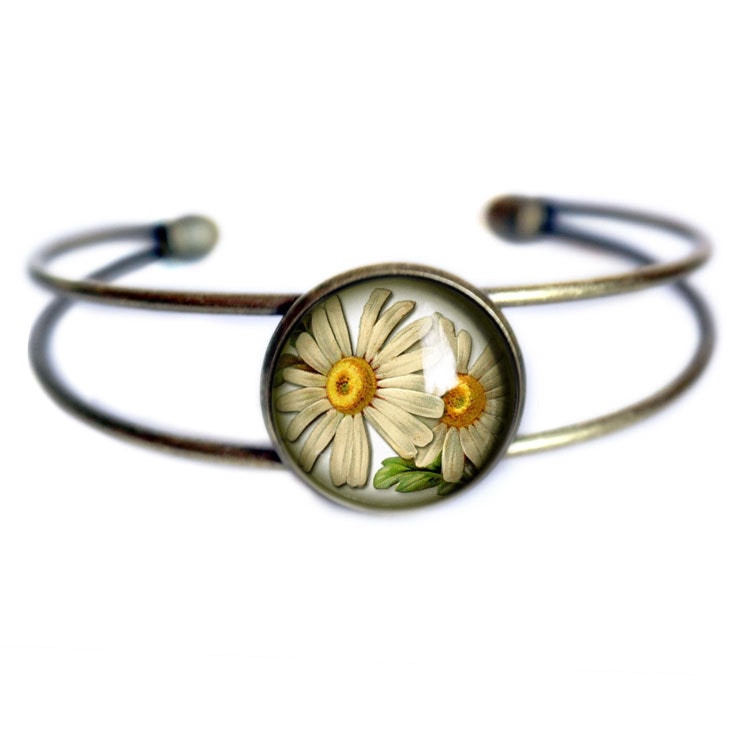 Bild på ett stelt manschettarmband med en illustration av prästkragar.