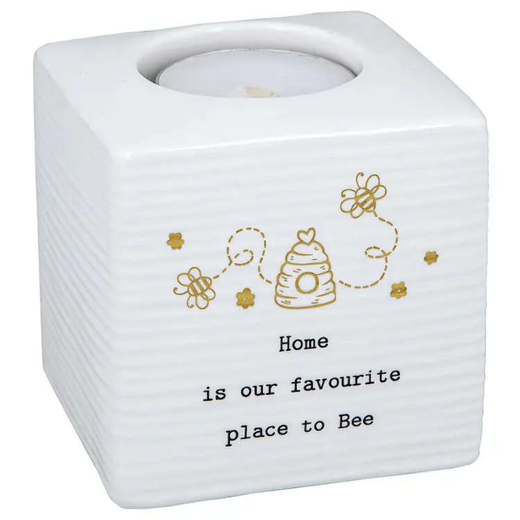 Vit kubformad ljushållare i keramik med texten "Home is our favourite place to Bee"