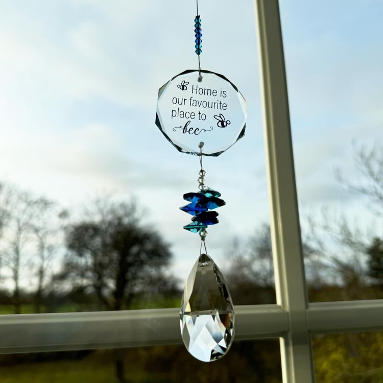 Bild på en solfångare med blå och genomskinliga prismor och texten "Home is our favourite place to bee"