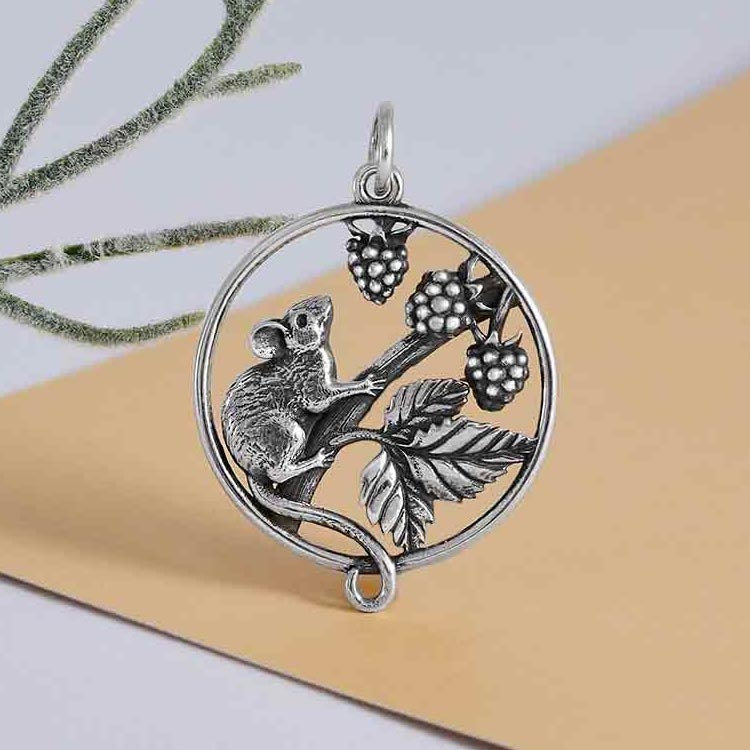 Runt silverhänge med en liten mus, björnbär och blad.