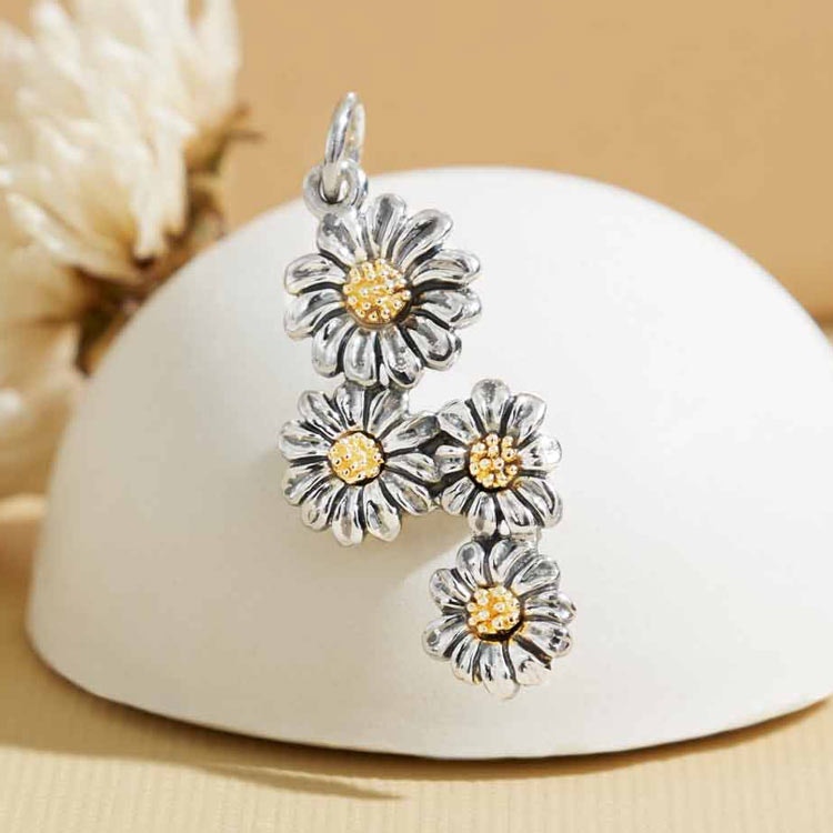 Silverhänge i form av fyra tusenskönor med detaljer i brons.