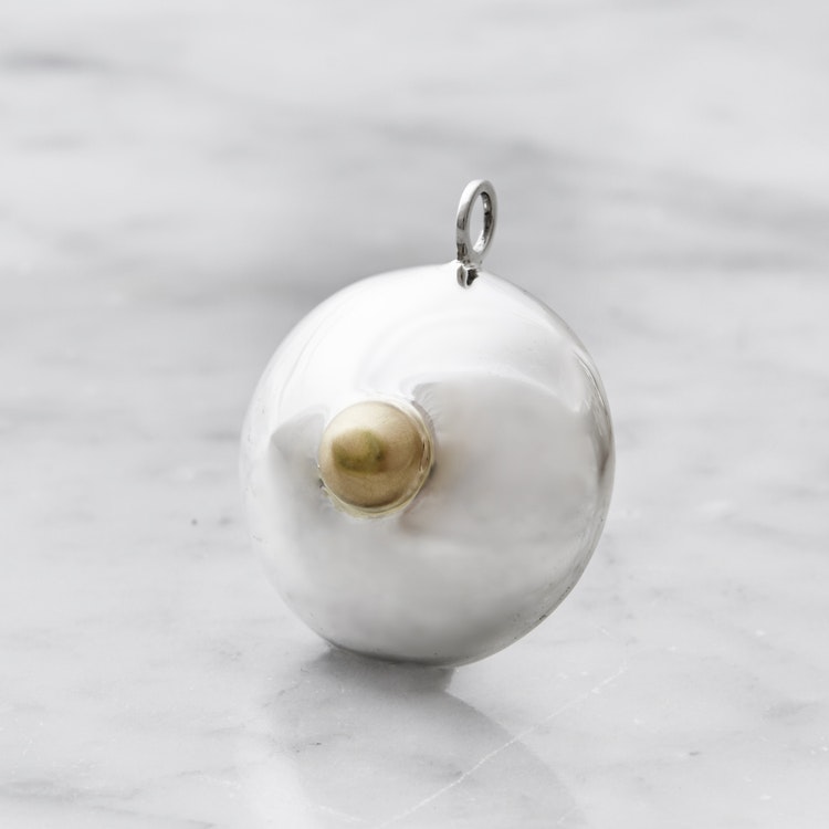 silverhänge i form av ett bröst, detalj i guld. silver pendant, shape as a breast detail with gold.