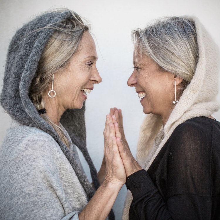 två kvinnor med silverörhängen med silverkulor. two women with same silver earrings with two globes