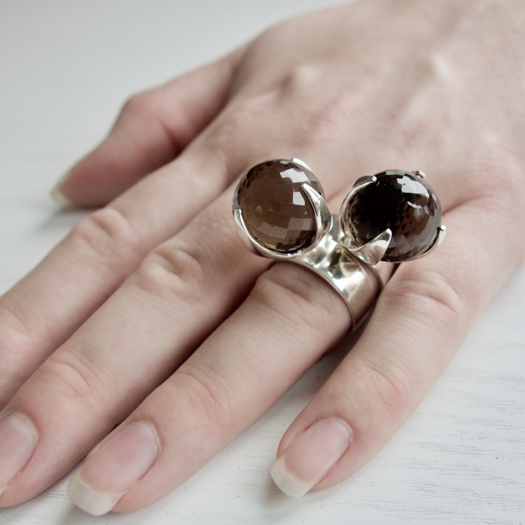 hand med två stora silverringar med rökkvarts. hand with two big silver rings with smokey quartz