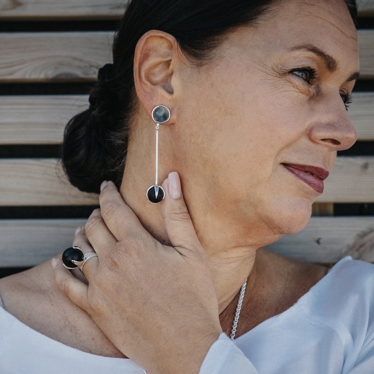 Modell med stora örhängen i silver med mattslipad svart onyx och matchande stor ring. Model with big silver earrings with mat black onyx and matching silver ring