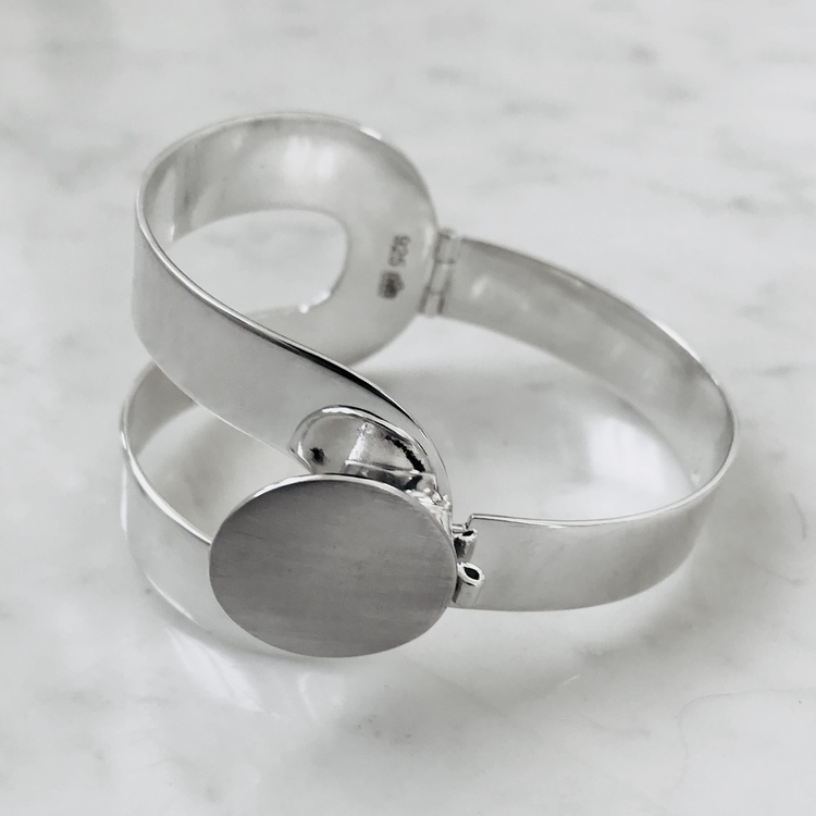 stort silverarmband, inspirerat av 70 talets pop- design, gångjärn och lås. Big silver bracelet with hinge and lock