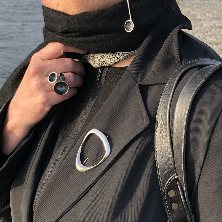 silverbrosch på en svart kavaj, silver brooch on a black jacket