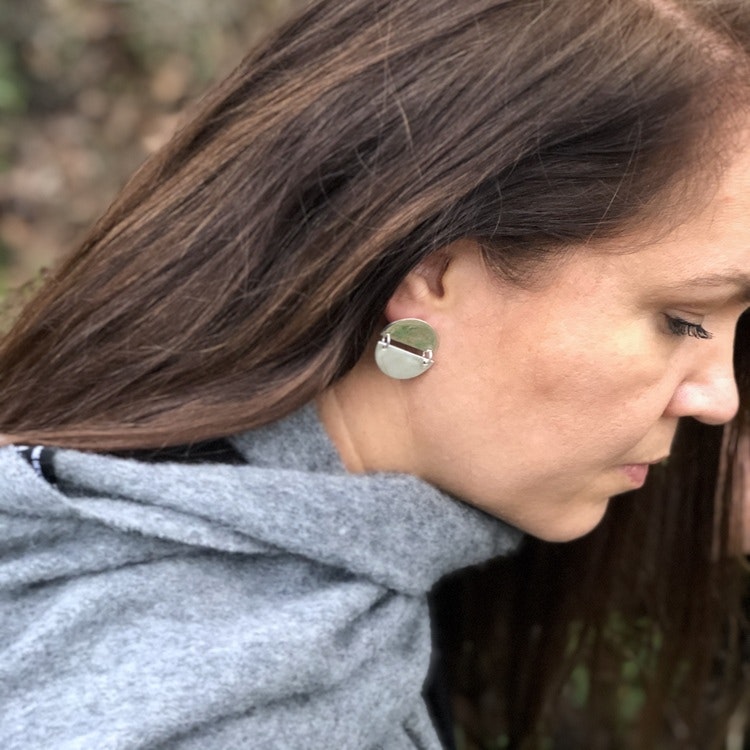 Kvinna med silverörhängen, två halvcirklar som hänger ihop. Woman with silver earrings, two connected half circles