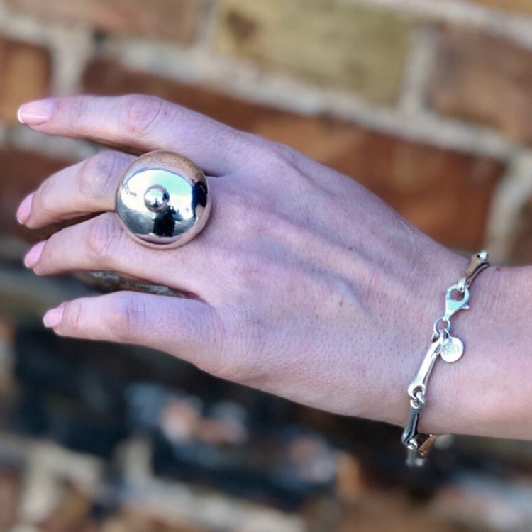 Model with Silverarmband som är ledat och mjukt format och en stor silverring. Model with Silver bracelet with a soft form and a big silver ring.