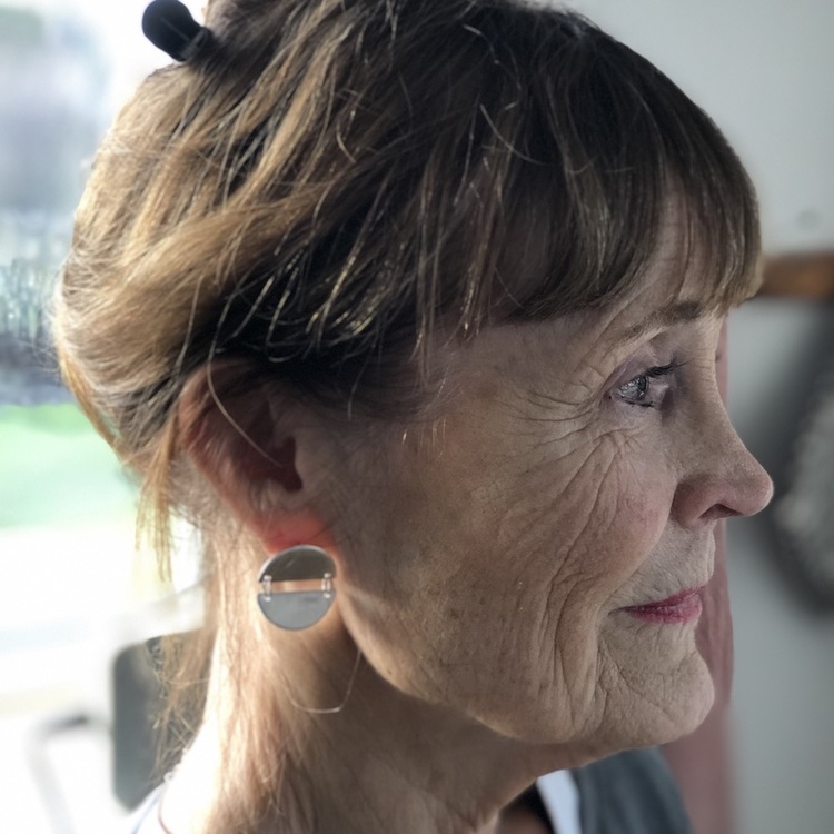 Kvinna med silverörhängen, två halvcirklar som hänger ihop. Woman with silver earrings, two connected half circles