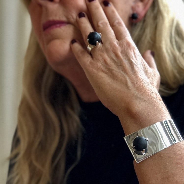 Arm med stort silverarmband och stor silverring med svart onyx. Arm with big silver bracelet and big silver ring with black onyx