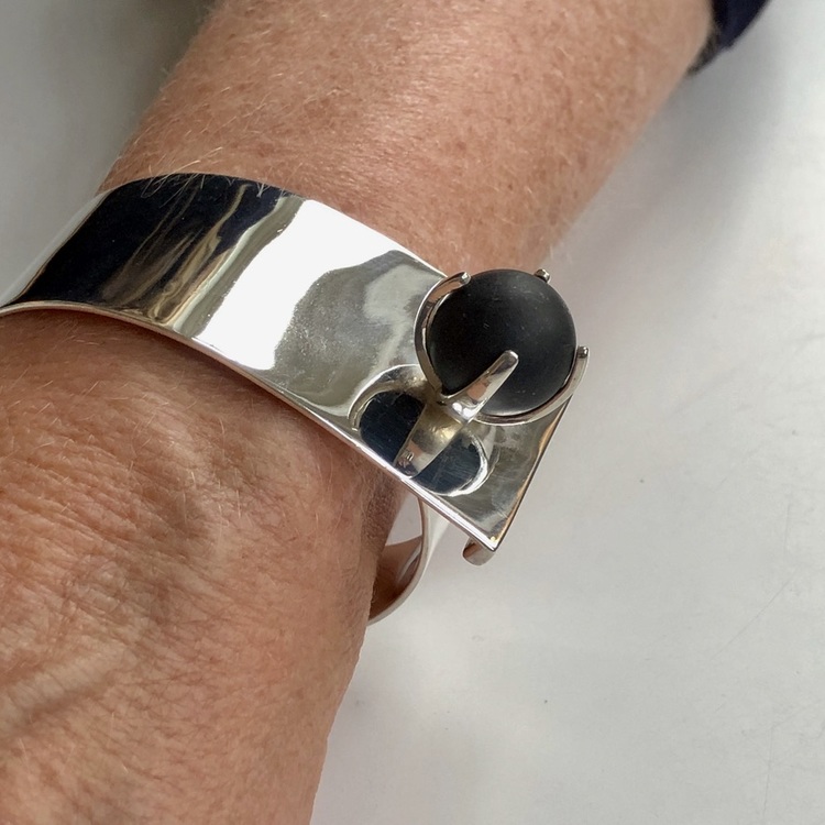 Arm med stort silverarmband med svart onyx. Arm with big silver bracelet with black onyx