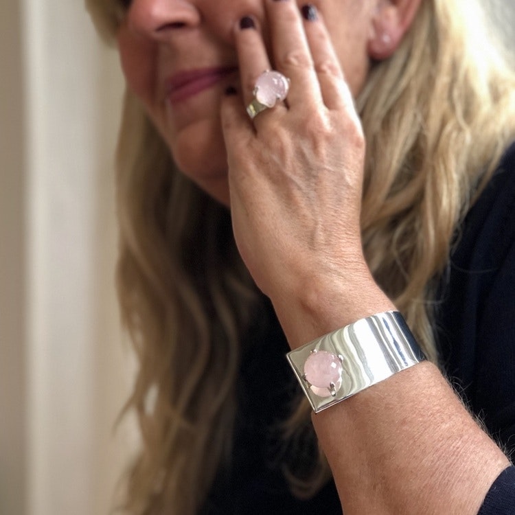 Kvinna med silverarmband  och stor ringa med rosenkvarts. Woman with silver bracelet and a big ring with rose quartz.