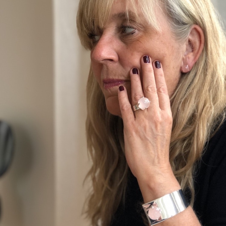 Kvinna med silverarmband  och stor ringa med rosenkvarts. Woman with silver bracelet and a big ring with rose quartz.