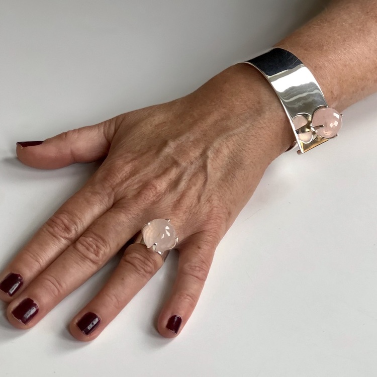 Hand med silverarmband  och stor ringa med rosenkvarts. Hand with silver bracelet and a big ring with rose quartz.