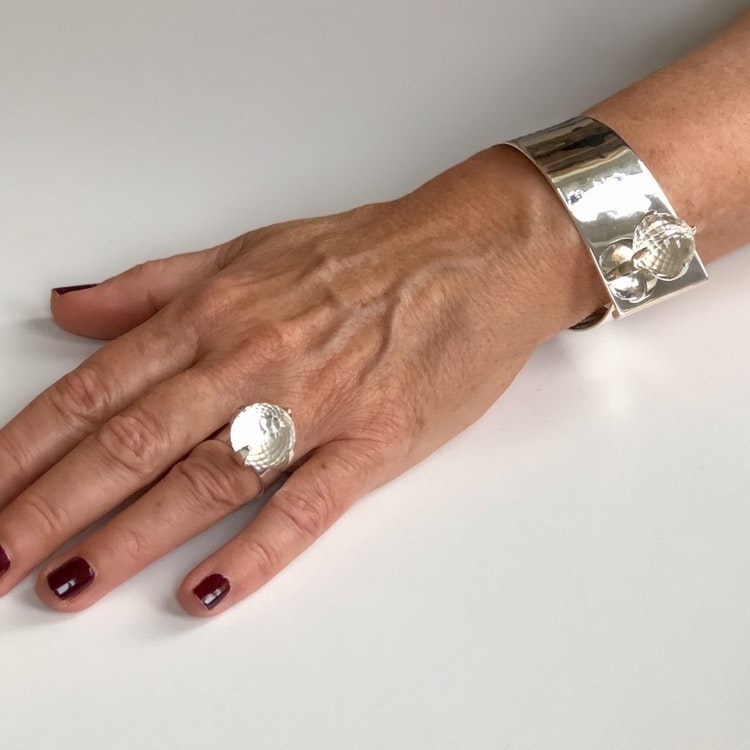 Arm med stort silverarmband och silverring med bergskristall. Hand with big silver bracelet and silverring with crystal quartz.