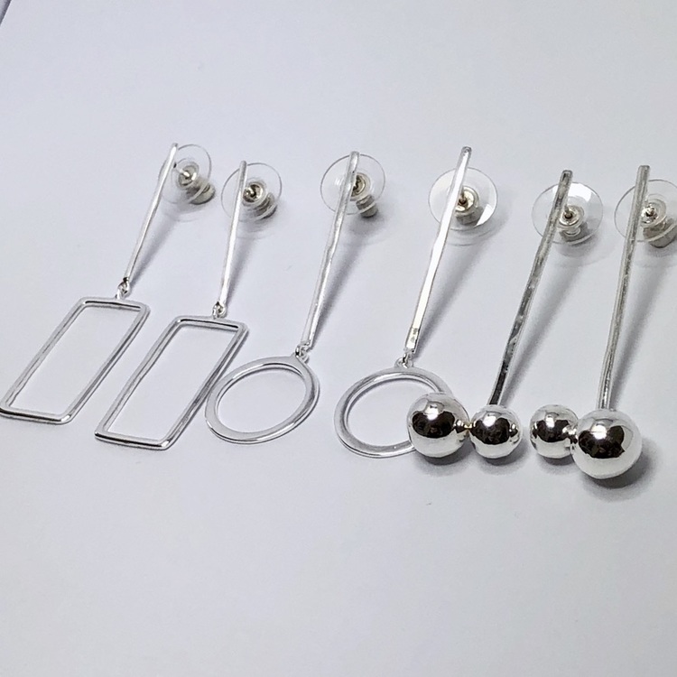 Tre varianter av silverörhängen. Three variations of silver earrings