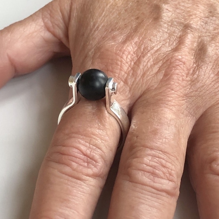 Hand med svarta silverringar med svart onyx. Hand with silver rings with black onyx.