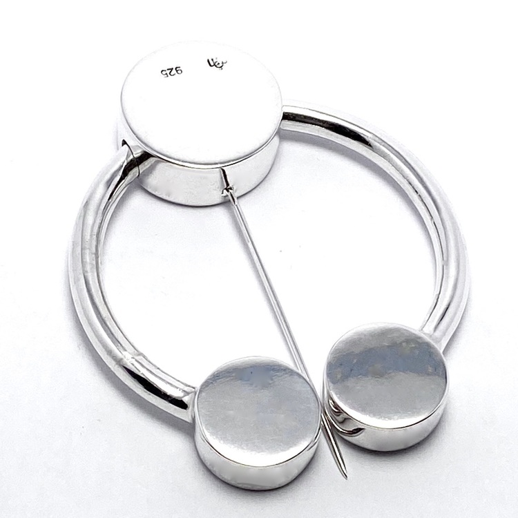 rund silverbrosch med form av omega. round silver brooch with the design from omega.