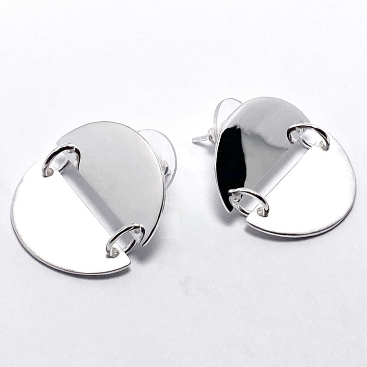 Silverörhängen med två halvcirklar som bildar en cirkel. Silver earrings with two half circles.
