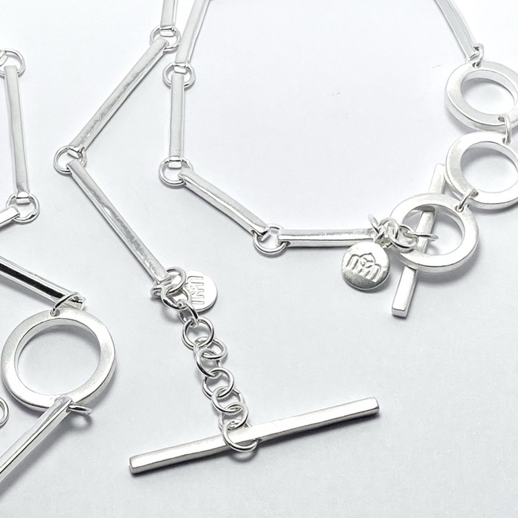 Silverarmband och silverhalsband med vackra silverstavar och cirklar. Silver bracelet and silver necklace with beautiful silver sticks and circles.